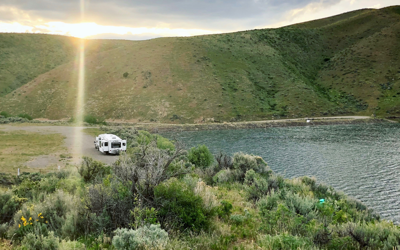 RV driving up to hills and lake/pond.