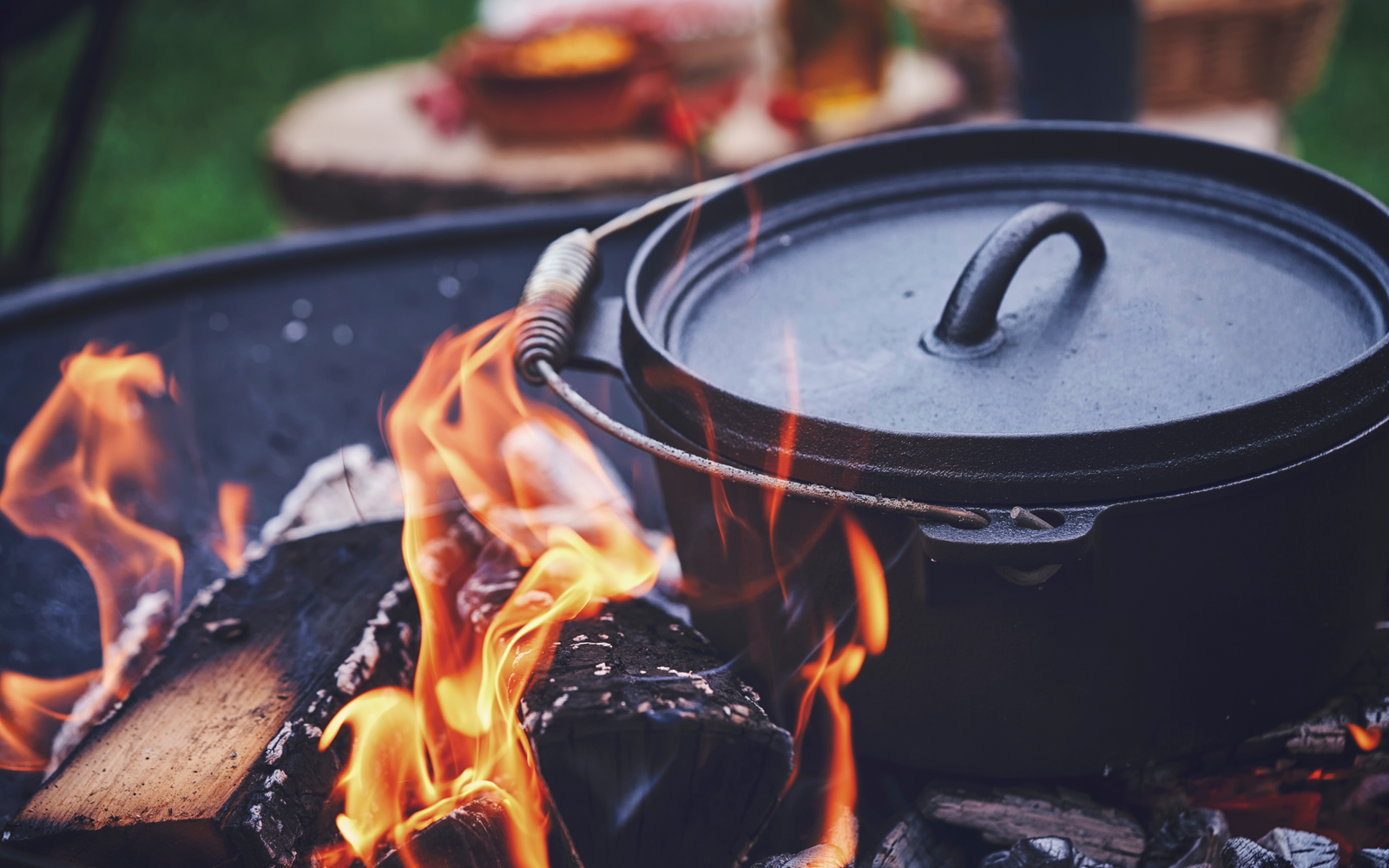 Closeup of a dutch oven with a flame and charcoal